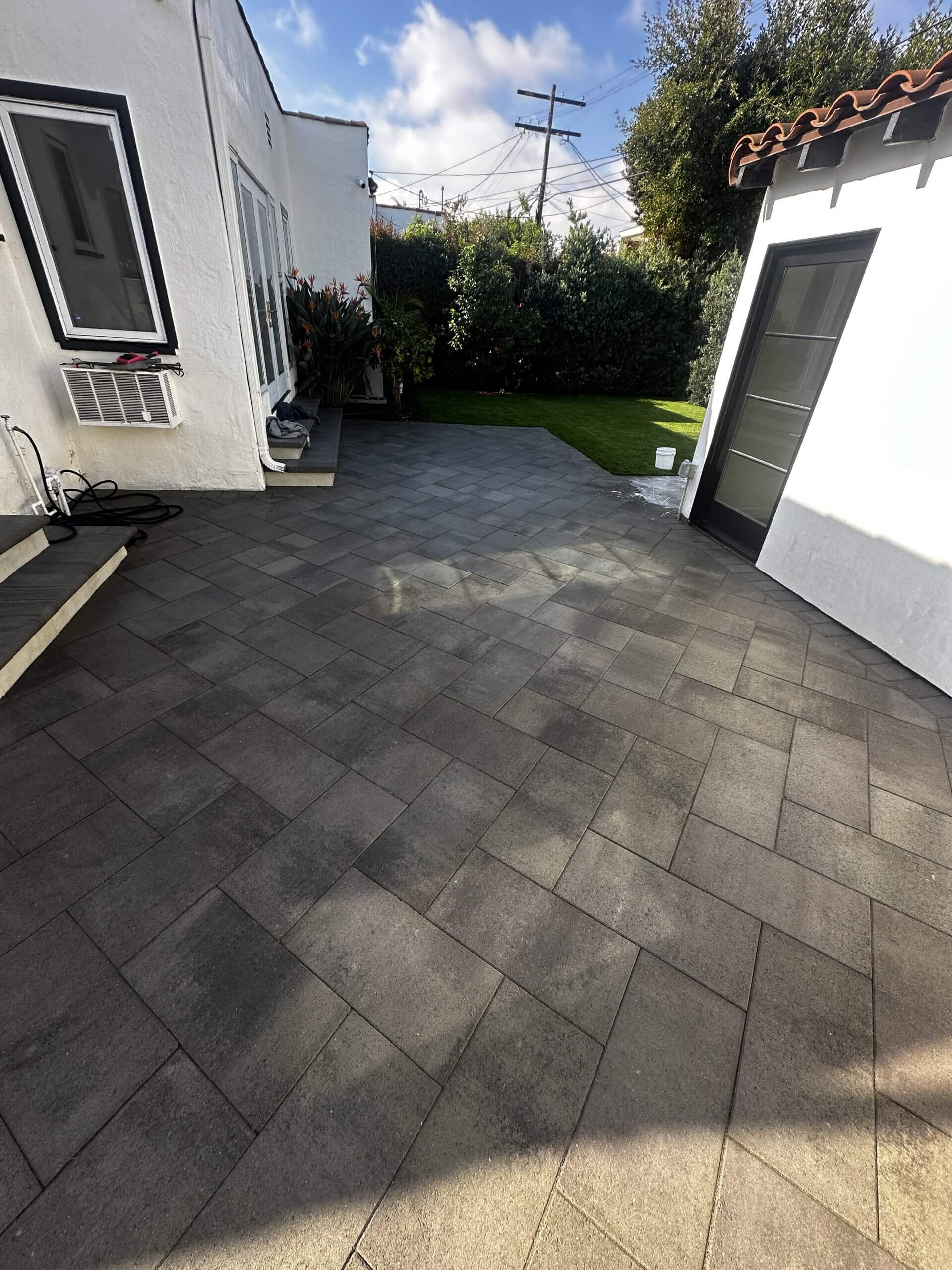 Paver patio with greenery and blue sky