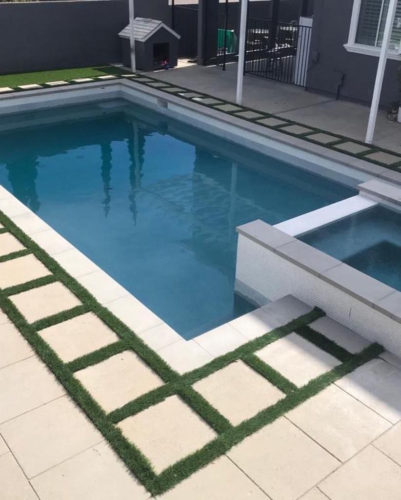 Rectangular pool and spa with turf-and-paver checkerboard deck