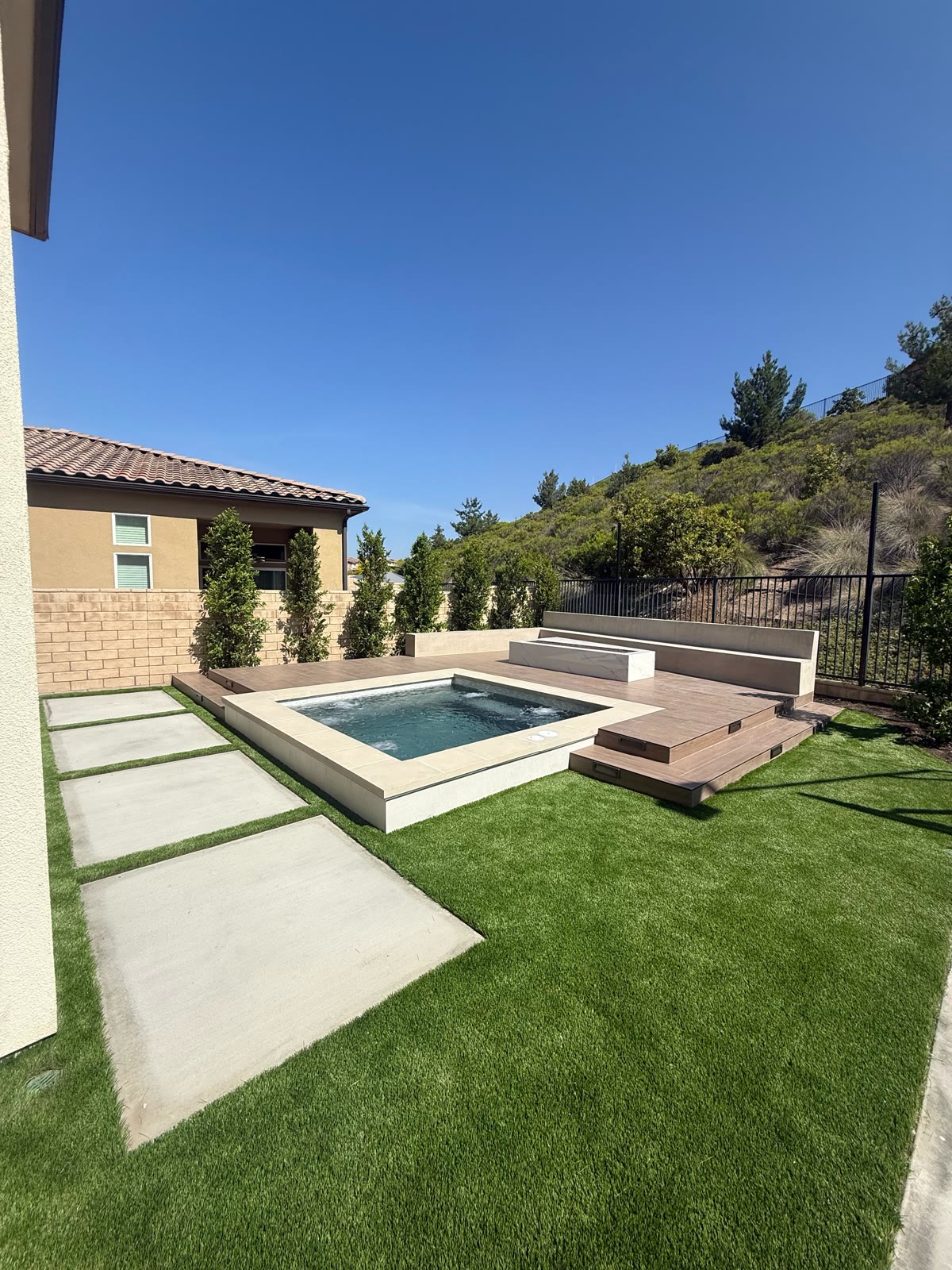 Modern raised spa with wood deck and hillside view