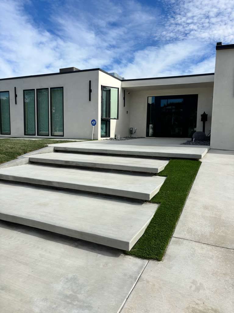 Broad cantilevered concrete steps at a modern home entry