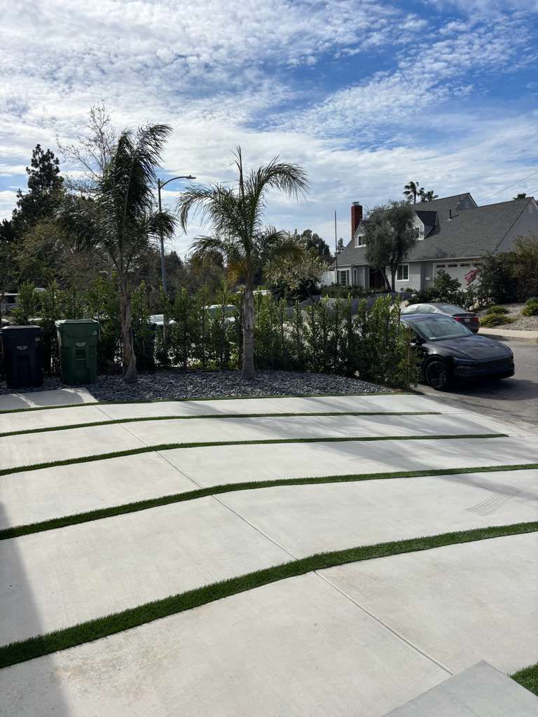 Concrete slab driveway with green turf joint strips