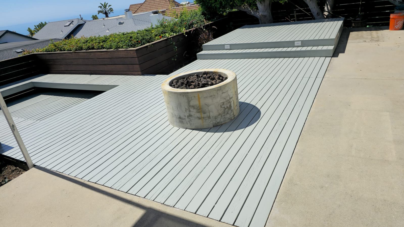 Wide gray composite deck with a concrete fire bowl centerpiece