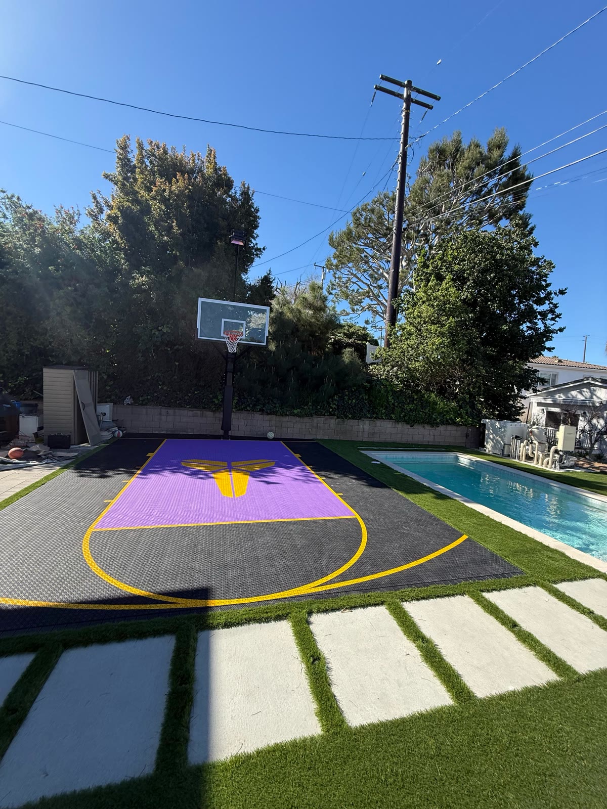Purple-and-black sport court with pool and blue sky