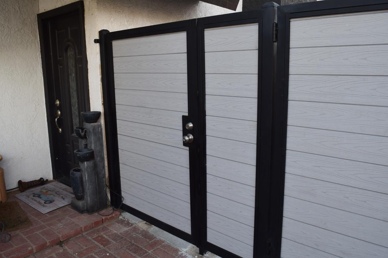 Light-gray composite fence with black-frame gate