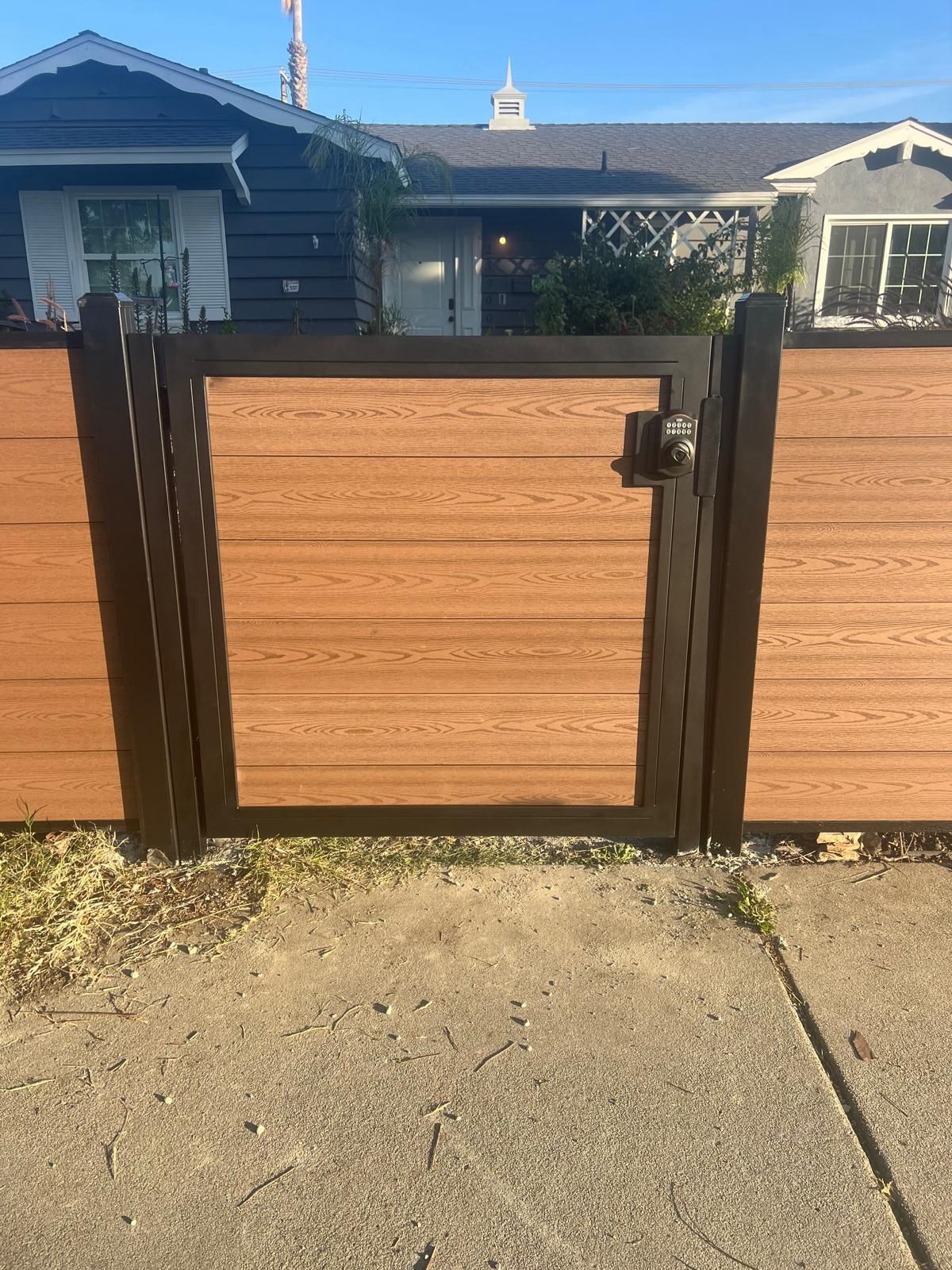 Woodgrain composite fence with keypad-lock gate