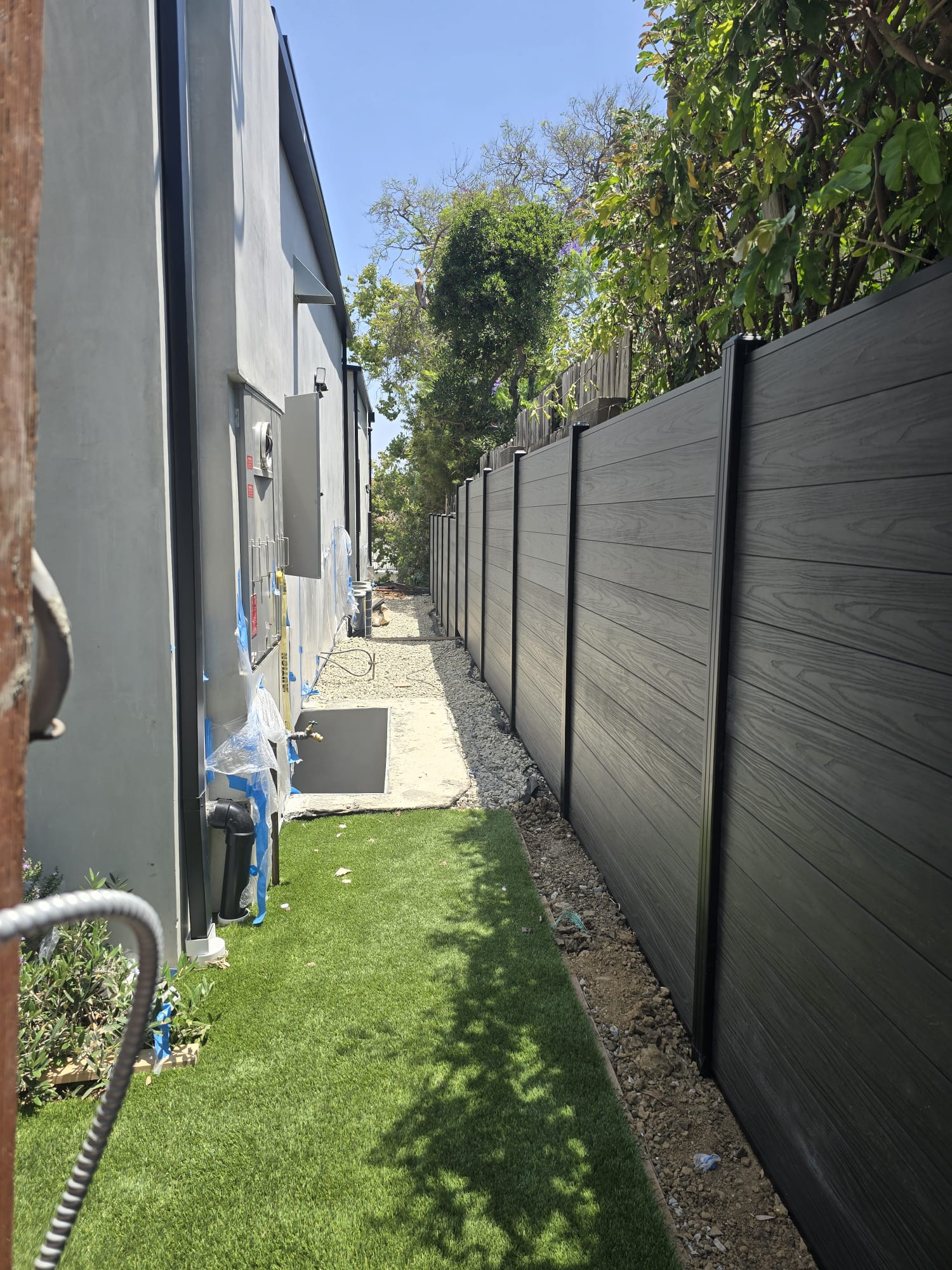Gray composite fence running along a side yard