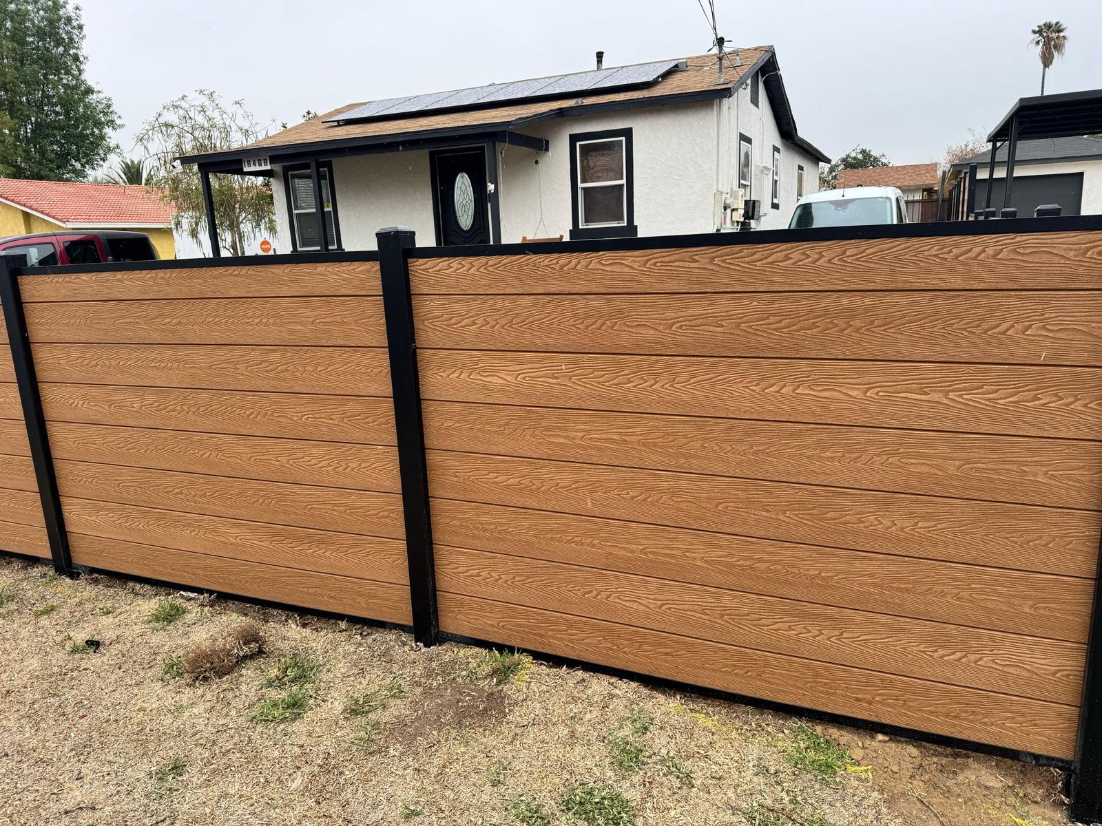 Woodgrain composite fence with black posts