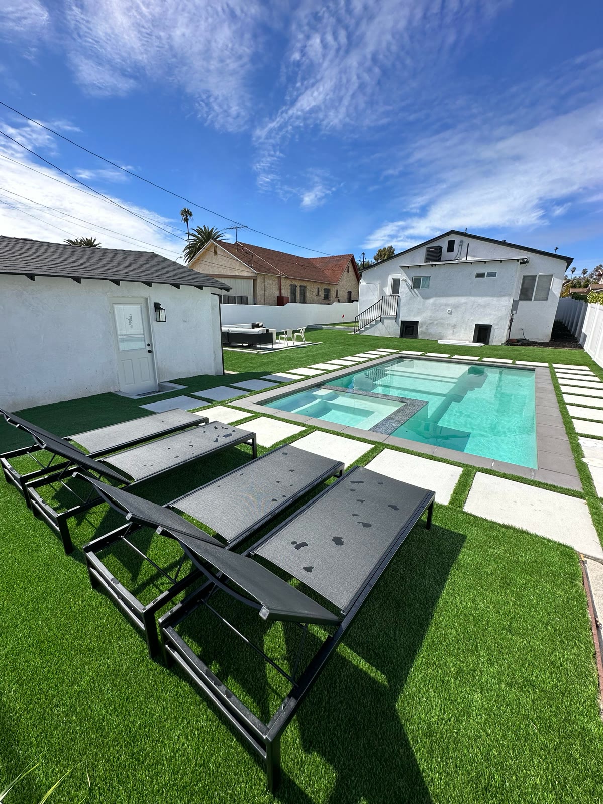 Pool and spa with sun loungers on a turf deck