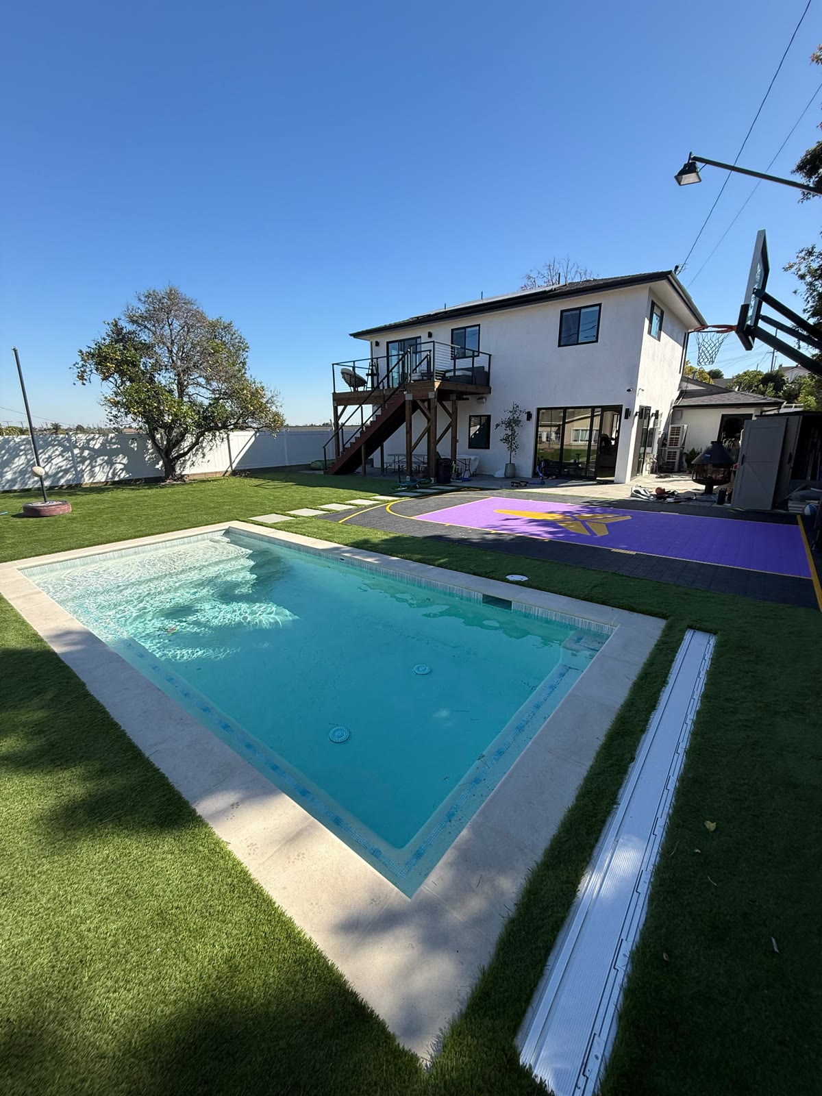 Rectangular pool with turf yard and sport court