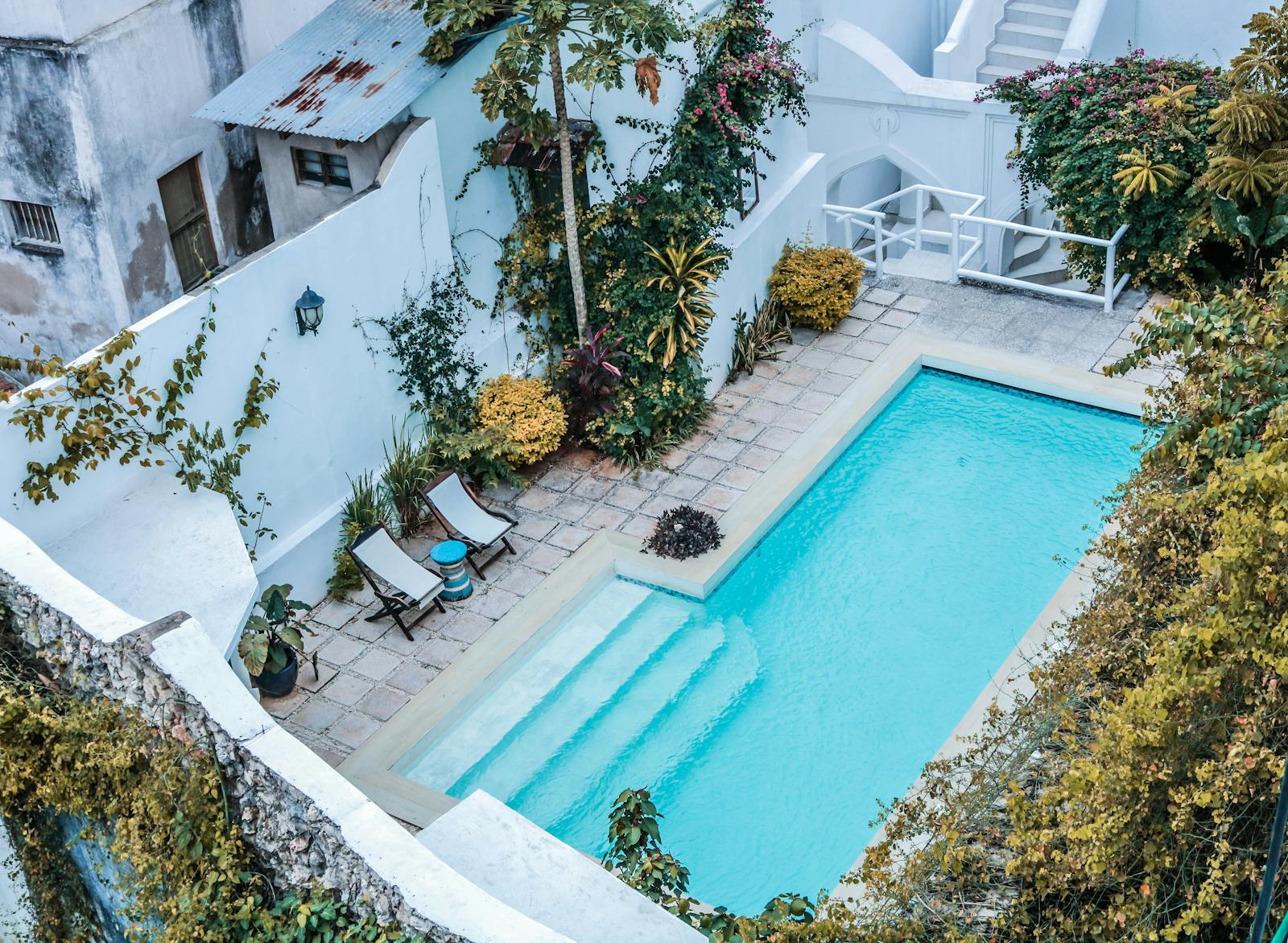 Backyard pool with stone-paved tile deck and patio