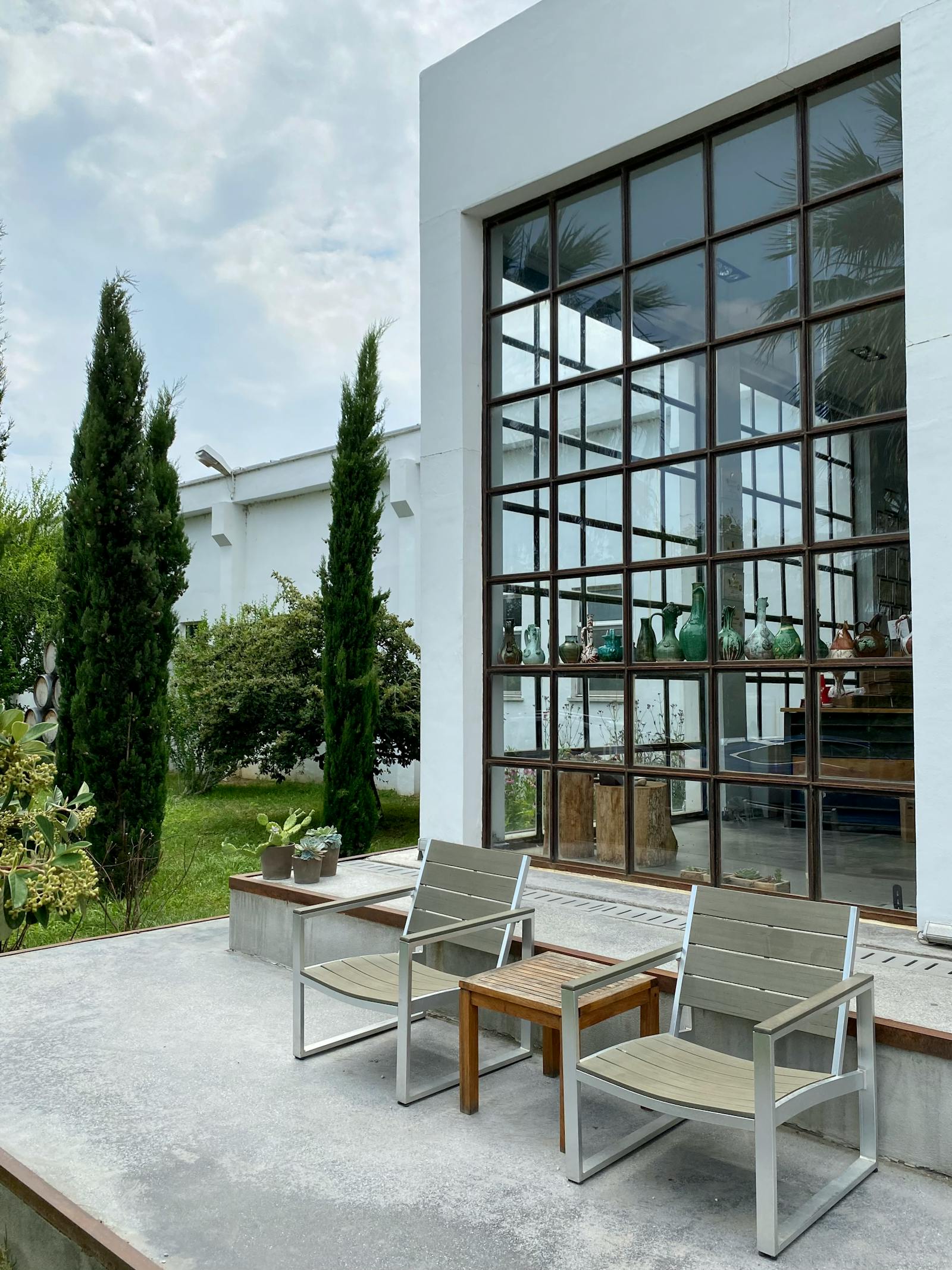 Tiled patio with seating beside a glass wall
