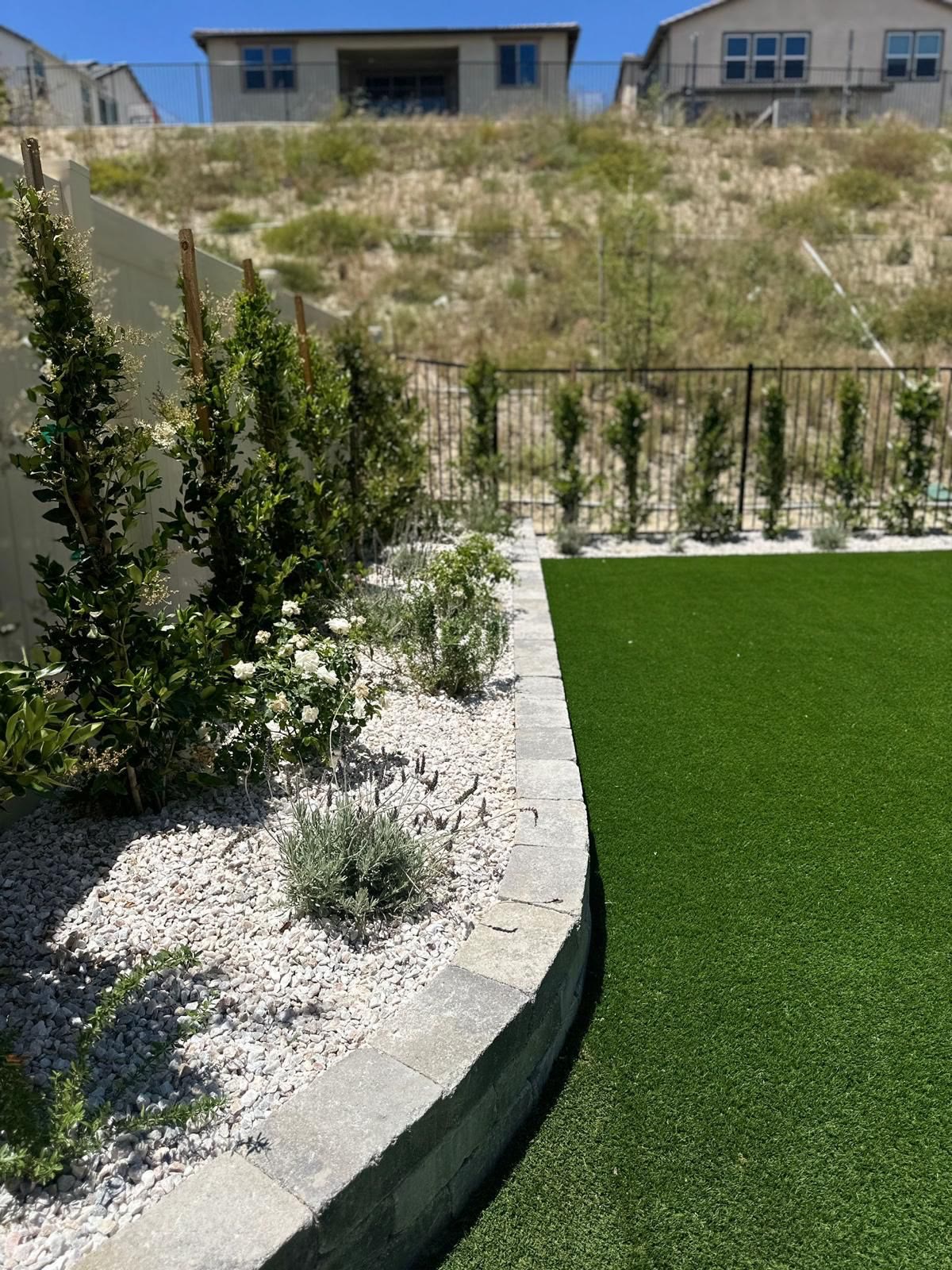 Turf lawn with stone-block border and planting bed