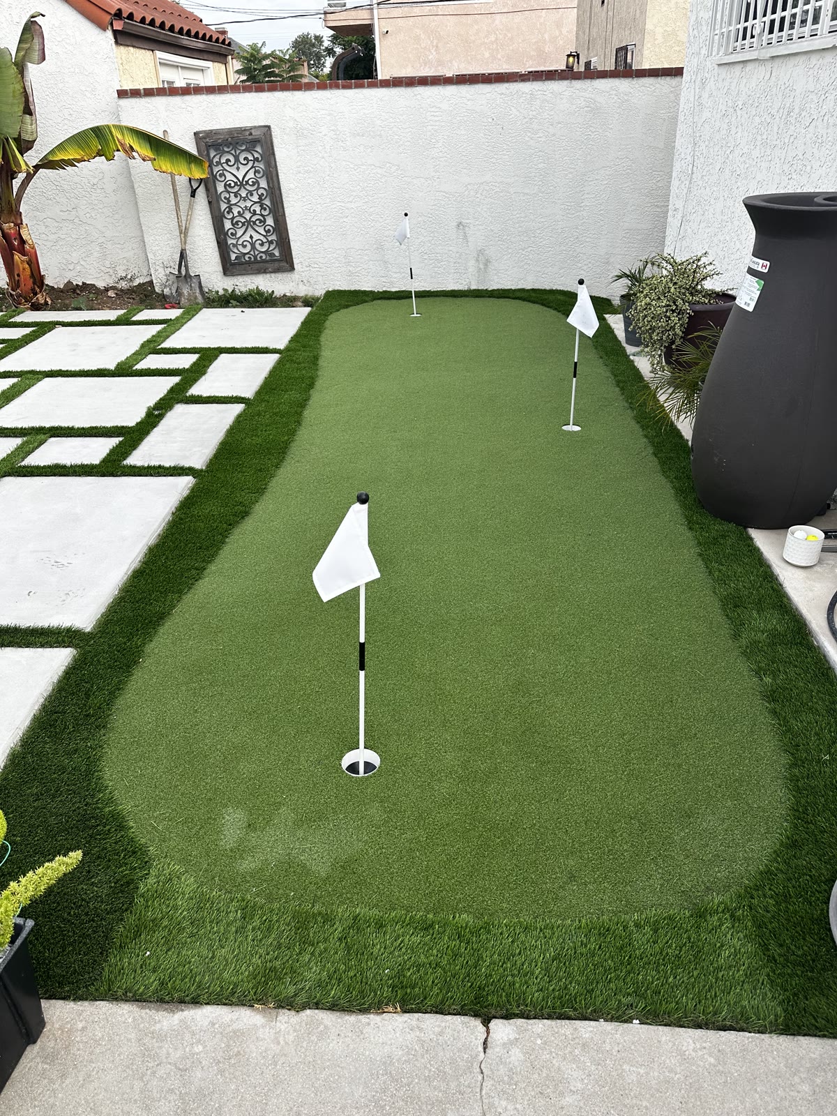 Backyard putting green with flags on artificial turf